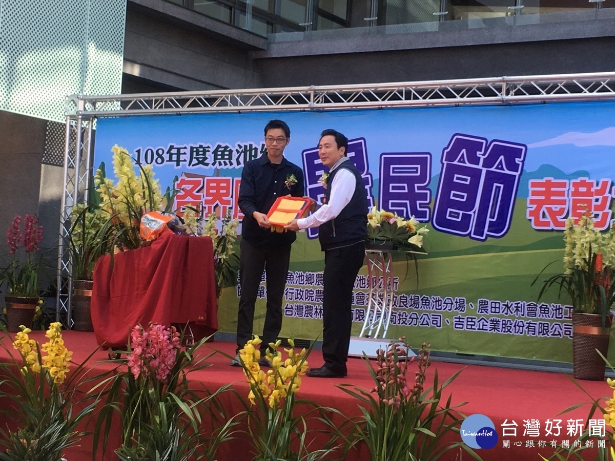 農民代表呈獻魚池鄉農業成果,由魚池鄉農會理事長劉啟行代表接受。〈記者吳素珍攝〉