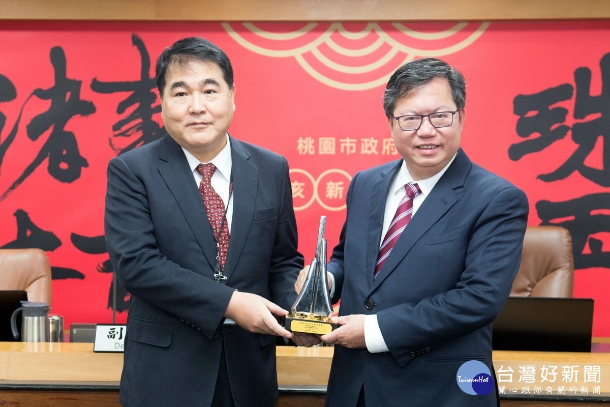 桃園市長鄭文燦在市政會議中接受水務局長劉振宇獻獎。