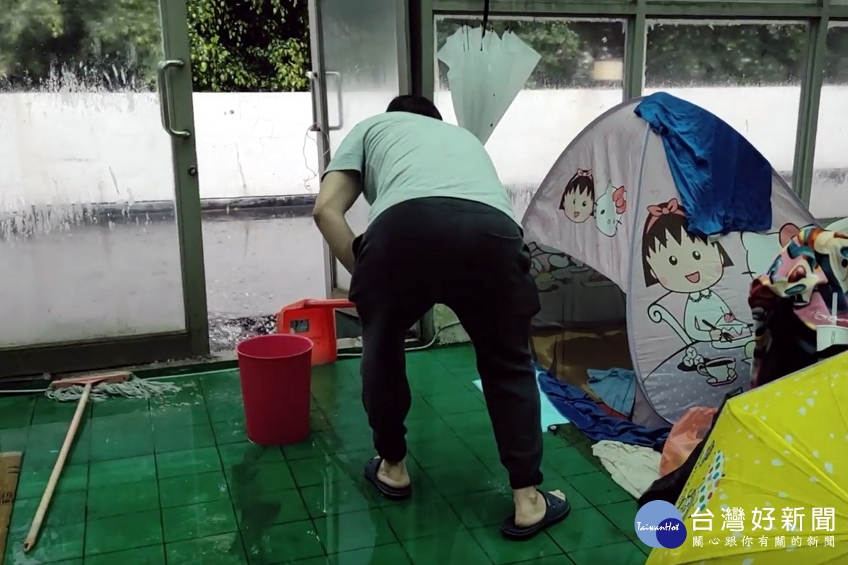 桃園市立游泳池休息區積水嚴重,選手家長只好用掃匝帚將水掃到外面。