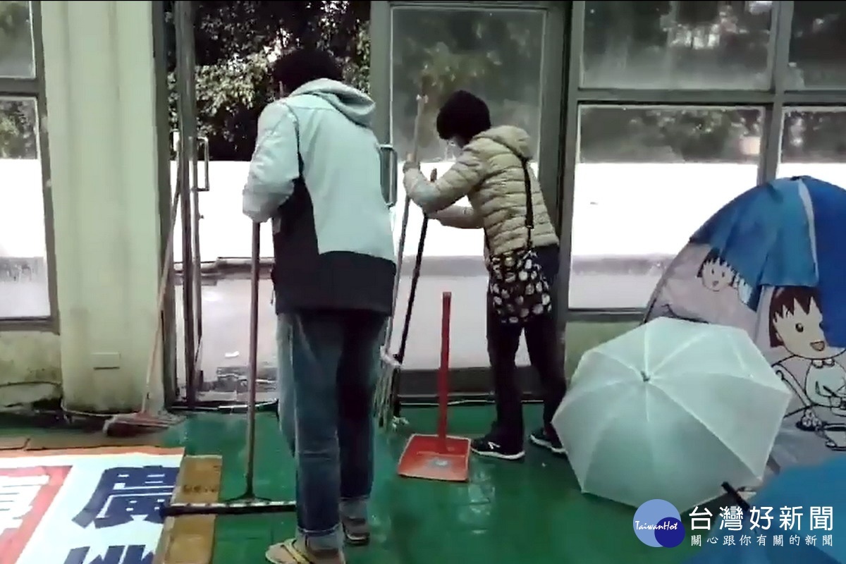 桃園市立游泳池休息區積水嚴重,選手家長只好用掃匝帚將水掃到外面。