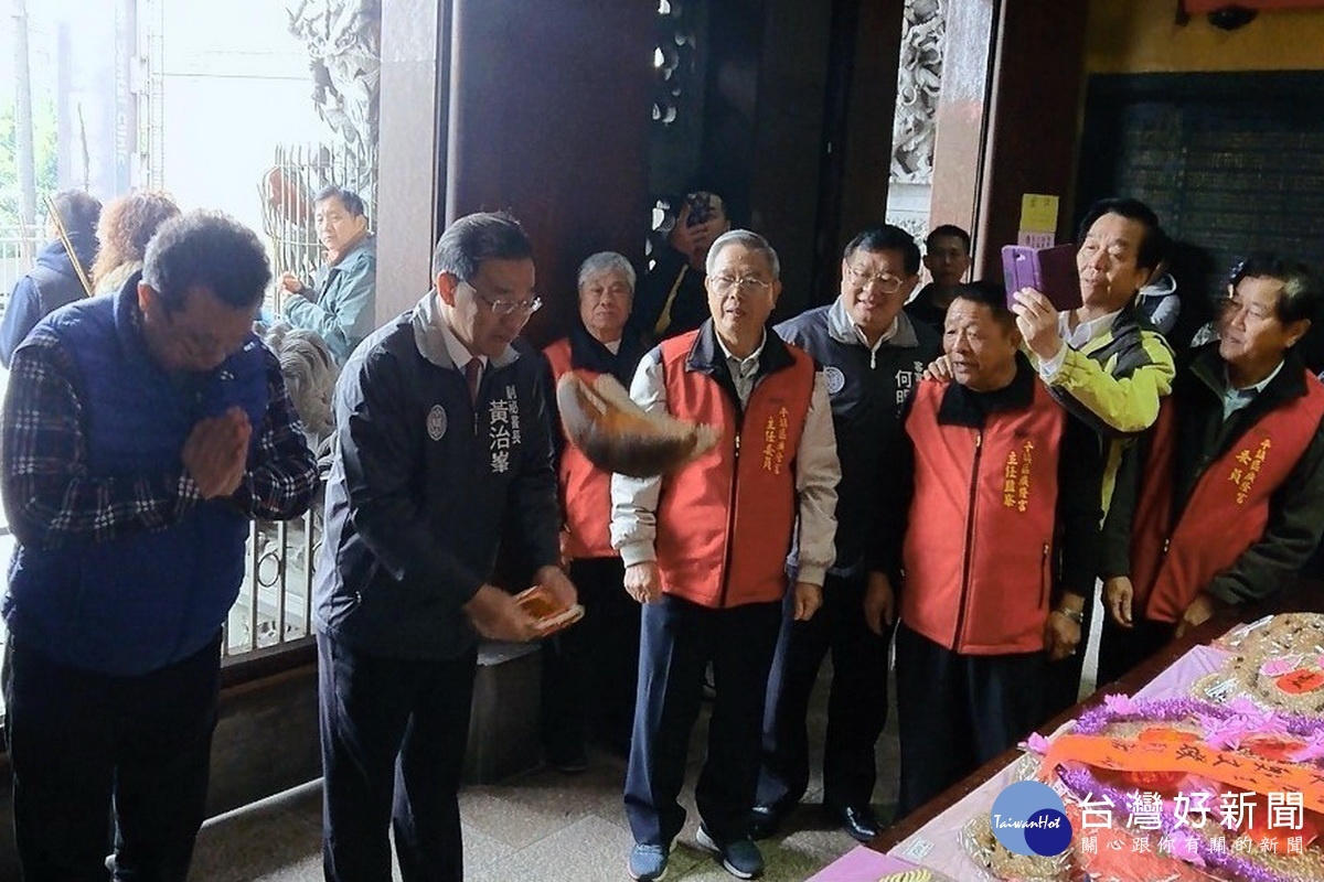桃園市政府副秘書長黃治峯在平鎮廣隆宮與民眾一同擲筊祈壽龜,祈求平安順利。
