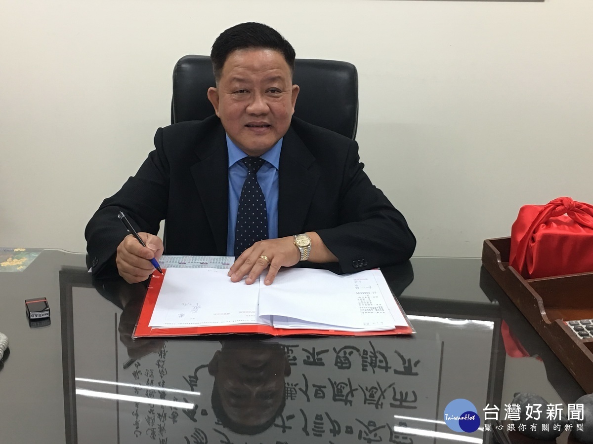 周義雄上任簽下第一份公文。(記者扶小萍攝)