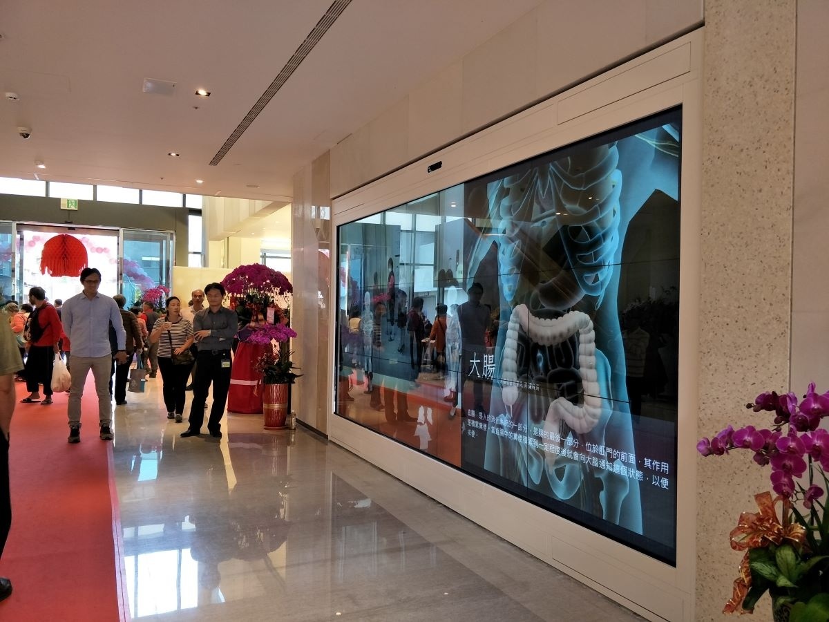 大廳一樓的互動牆,民眾能觸碰牆上視窗閱讀秀傳發展歷史及醫院介紹等,還有結合娛樂性質的擴增實境(AR)功能,將虛擬的人體內部臟器影像資訊,顯示於互動牆上,如感受X光掃描般的驚喜,並可點選臟器進行衛教分享,且有拍照功能,能將牆面呈現虛擬影像結合現場實境的畫面透過掃描QR code將圖檔存到手機裡。圖/記者鄧富珍攝