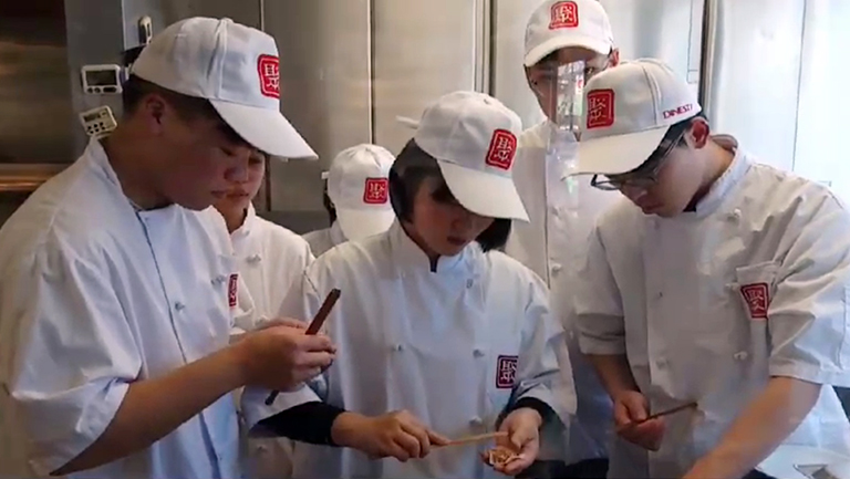 ▲在加拿大實習餐廳廚房內，餐飲科同學們開始進行包餃子實習課程（見圖）。（影片翻攝）