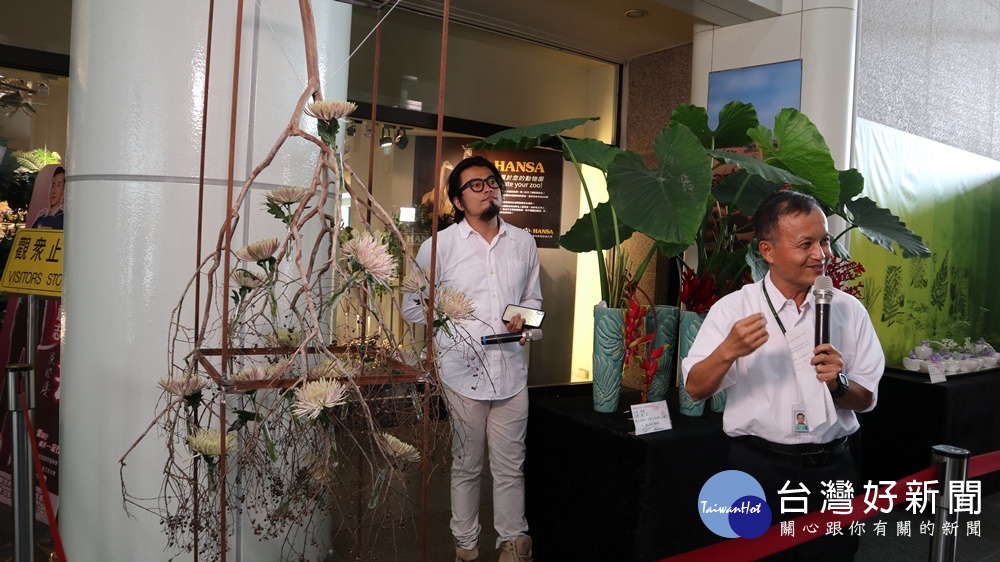國立自然科學博物館舉辦清明花藝展，嚴新富博士跟花藝老師說明使用九芎的特色及造型。(圖/記者賴淑禎攝)