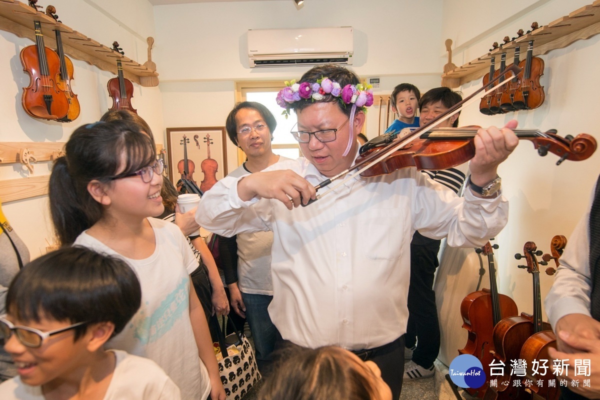 桃園市長文燦參加「南崁兒童藝術村」營運開幕典禮體驗拉小提琴。