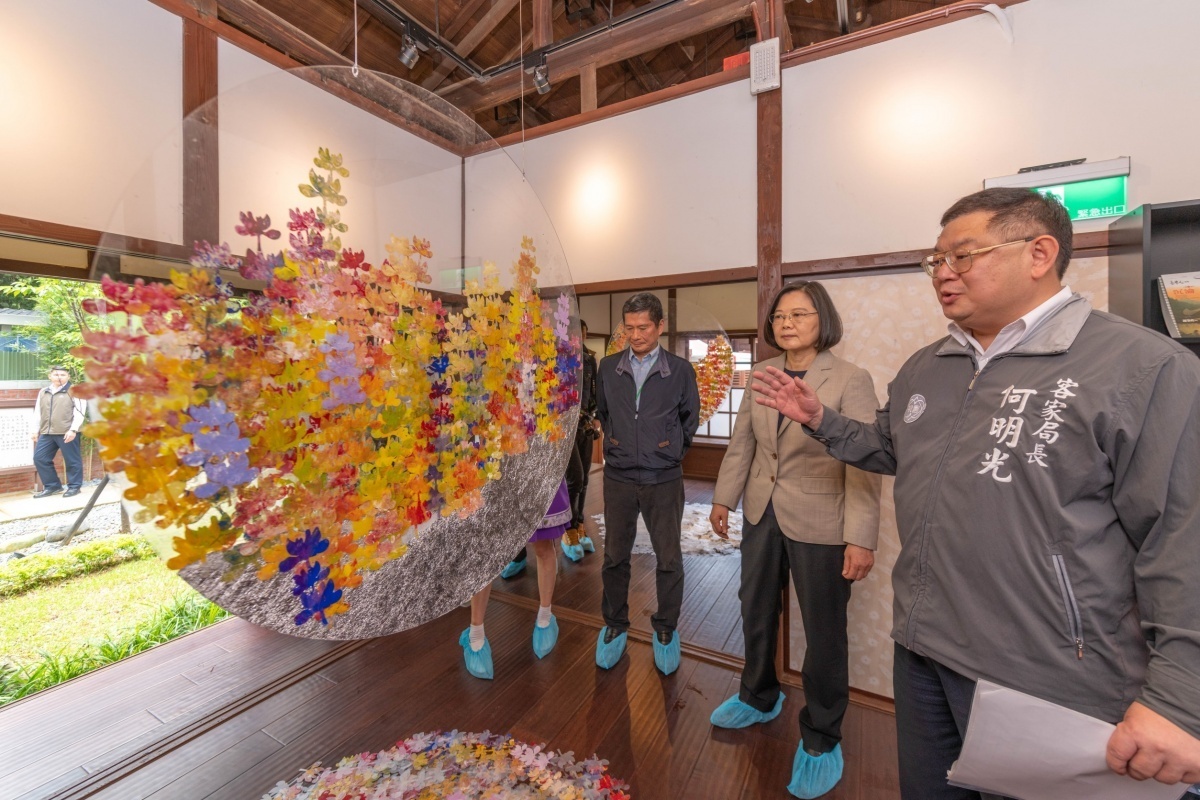 客家局長何明光解說客籍藝術家張雅萍與龍潭國小的孩子們共同創作的作品《花河長流》。