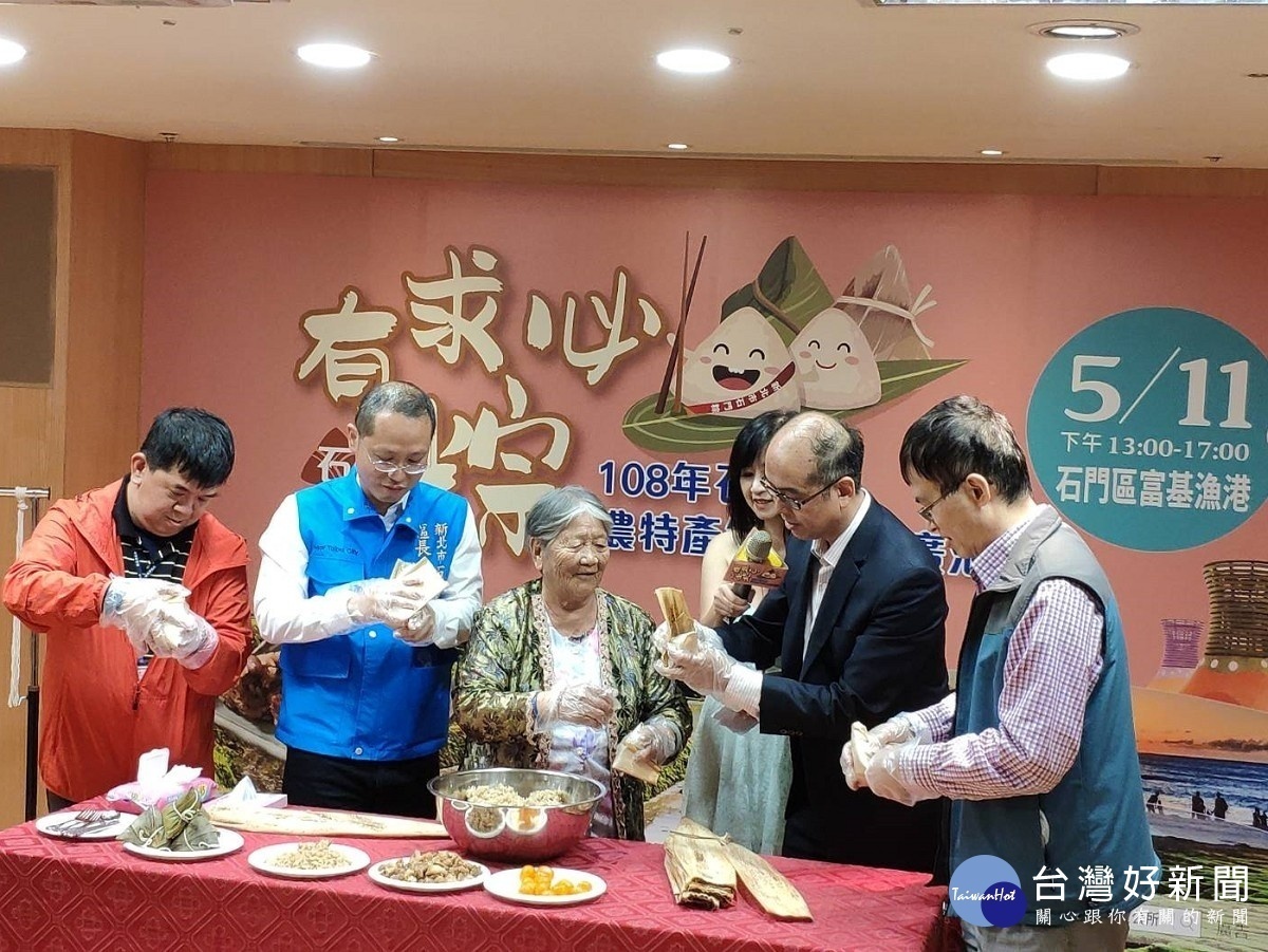 記者會現場特別邀請94歲資深肉粽達人林蜂阿嬤帶領民政局副局長范姜坤火、石門區區長林俊宏及現場貴賓一同親手包肉粽,一展好手藝。(圖/記者黃村杉攝)