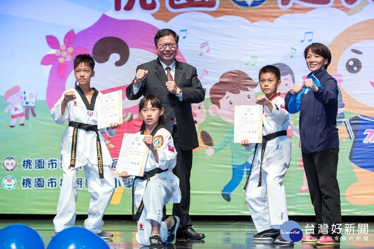 桃園市長鄭文燦與接受表揚的跆拳道代表隊選手合影。