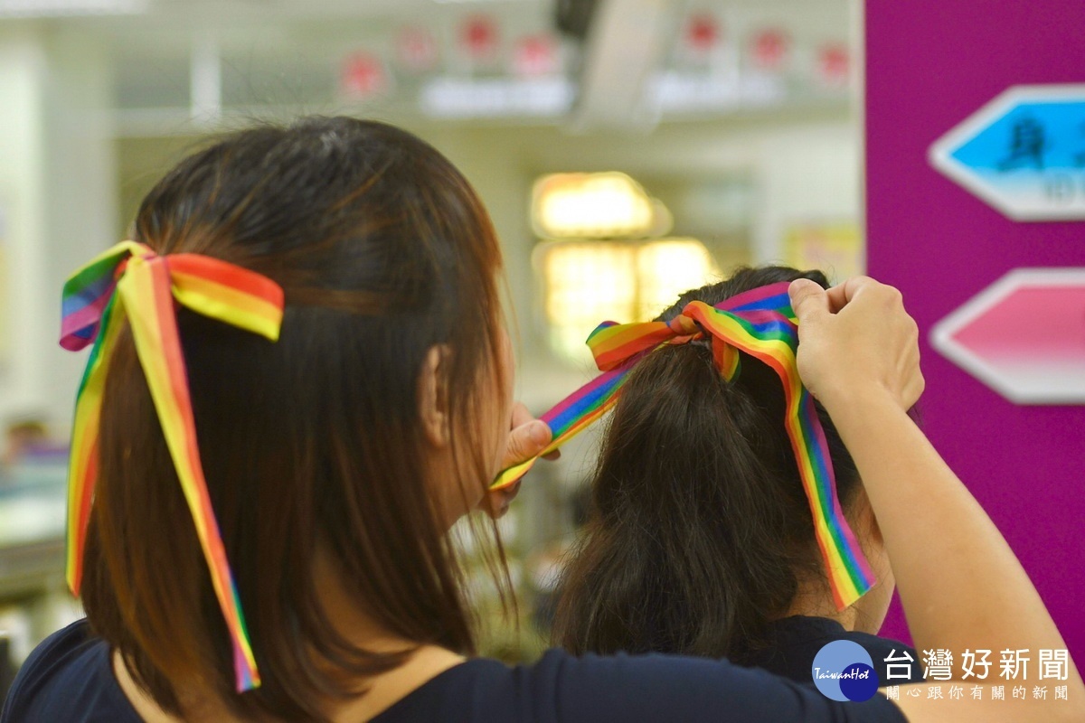在辦理結婚登記前，吳少喬與邱明玓相互綁上彩虹髮帶。