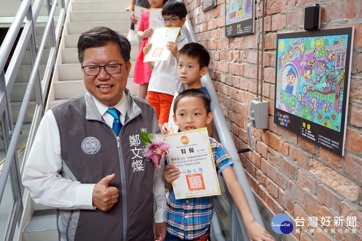 桃園市長鄭文燦與獲得國小低年級特優獎建德國小劉華晏同學合影。