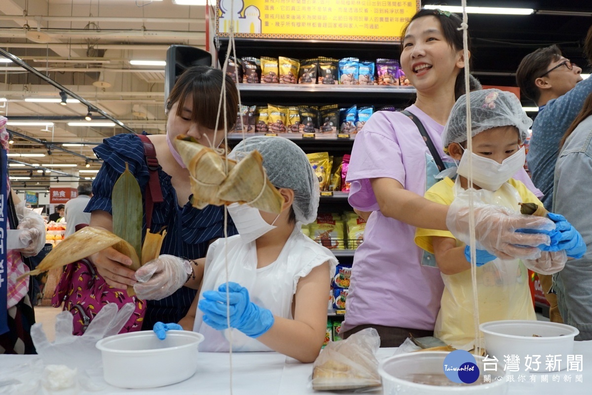 在包粽大賽中,親子攜手合作包粽子,現場洋溢幸福快樂的氣氛 。