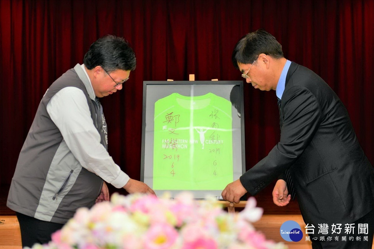 桃園市長鄭文燦與亞東創新發展股份有限公司副總經理張丙秋共同在環保衣上簽名。