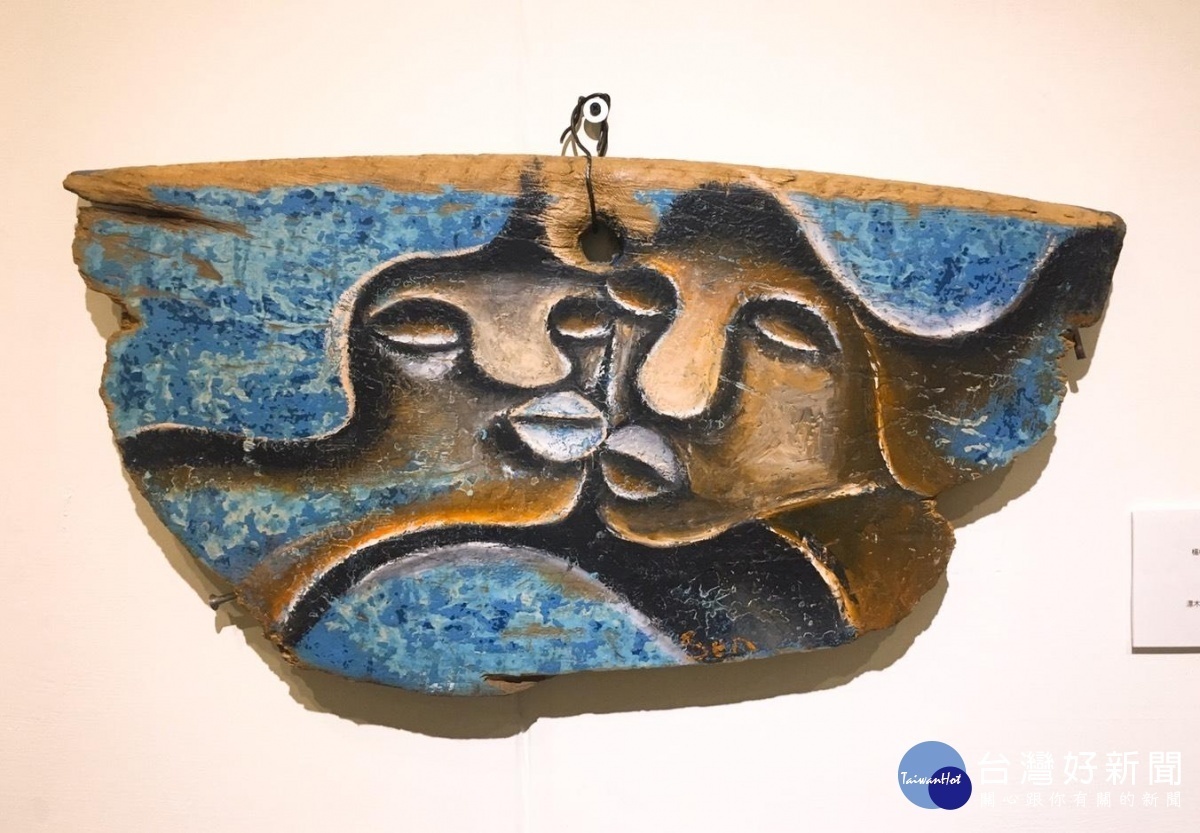 楊樹森作品《甜蜜蜜》以廢棄的船板作畫，藝術家保留船版原始樣貌與藍色繪製出兩個人的臉龐