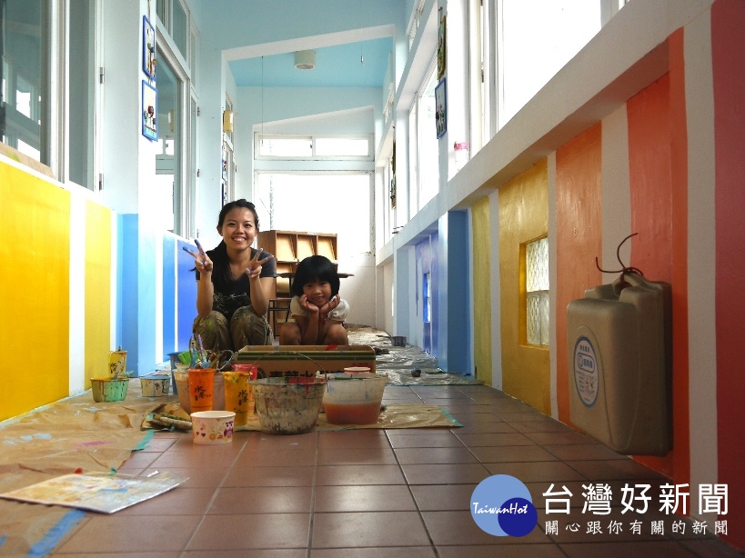 王惠苹彩繪學校牆面時與小朋友一起工作的畫面