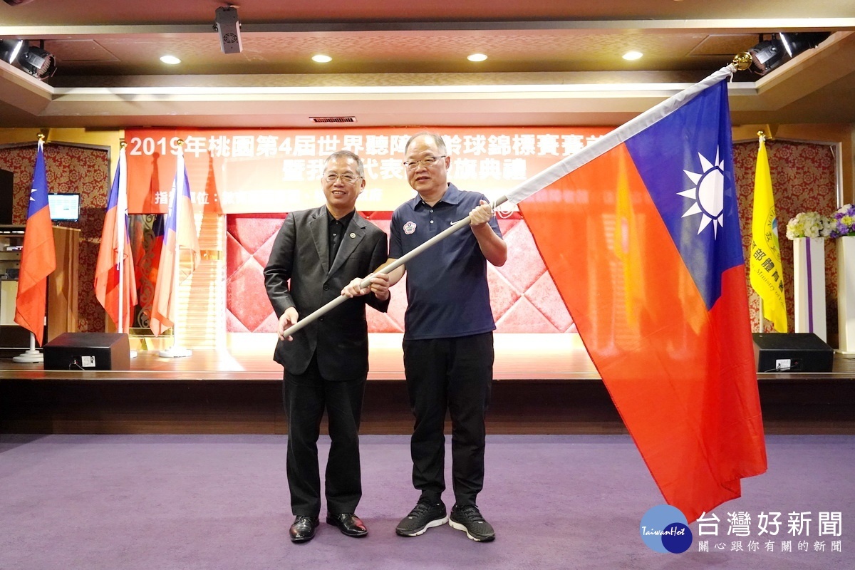 教育部體育署主任秘書葉丁鵬將國旗授予中華民國聽障者體育協會秘書長趙玉平。