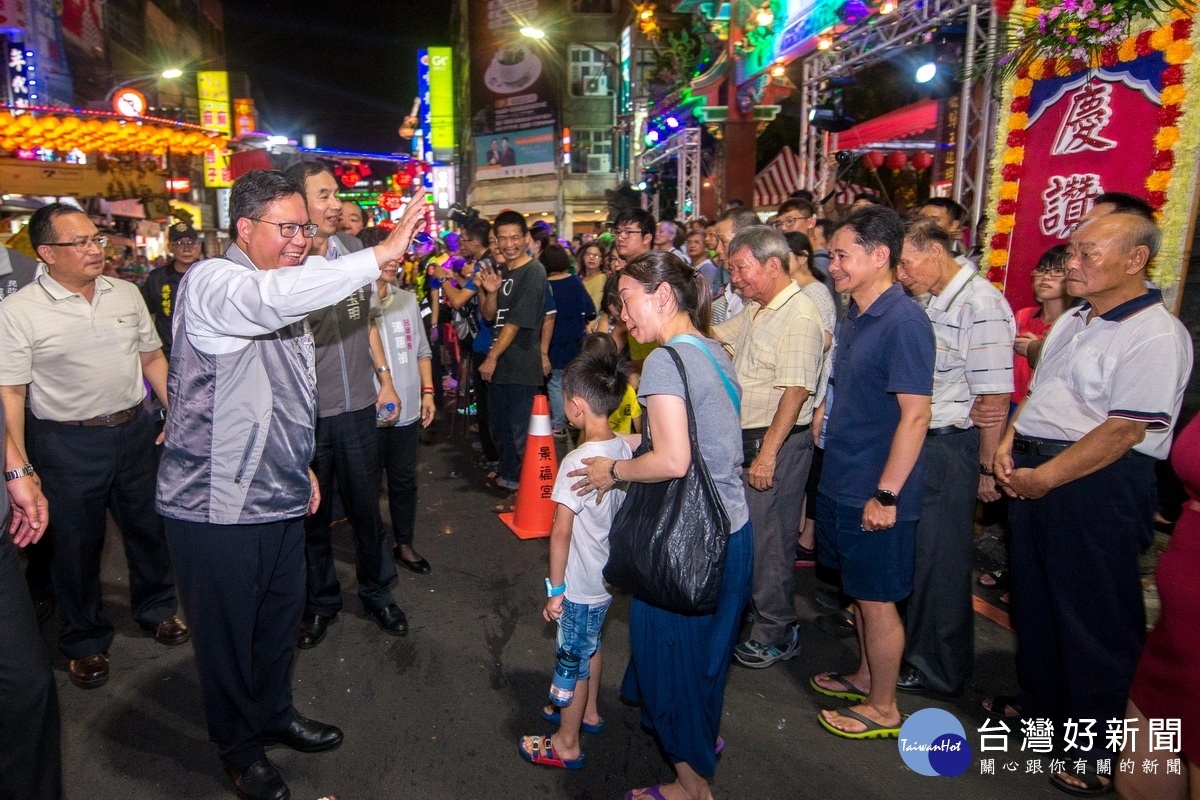 桃園市長鄭文燦參加慶讚中元水燈排車繞境活動，向熱情的民眾問好。