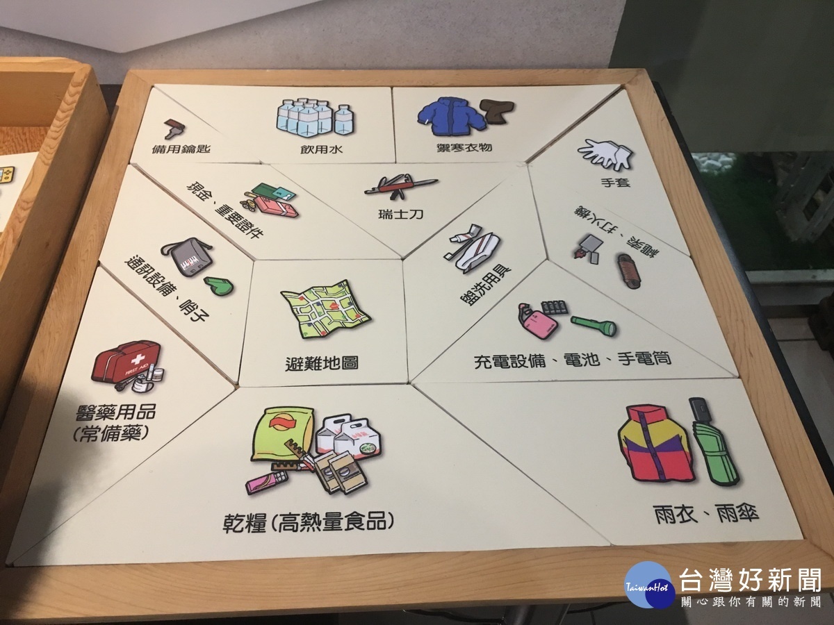 願力館內用七巧板原理製作避難包內容。(記者扶小萍攝)