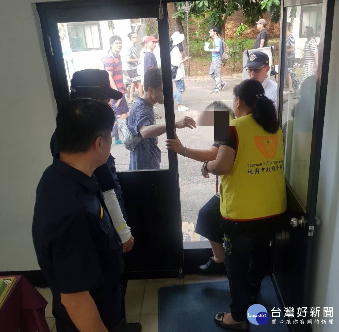 阿嬤站在樹下氣喘吁吁，員警立即上前協助引導到入口處機動派出所休息