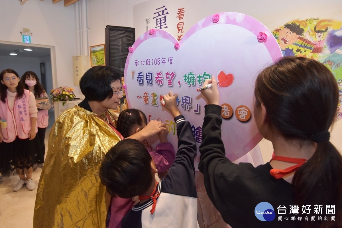 縣長王惠美在擁抱愛，童畫心世界記者會中簽名。