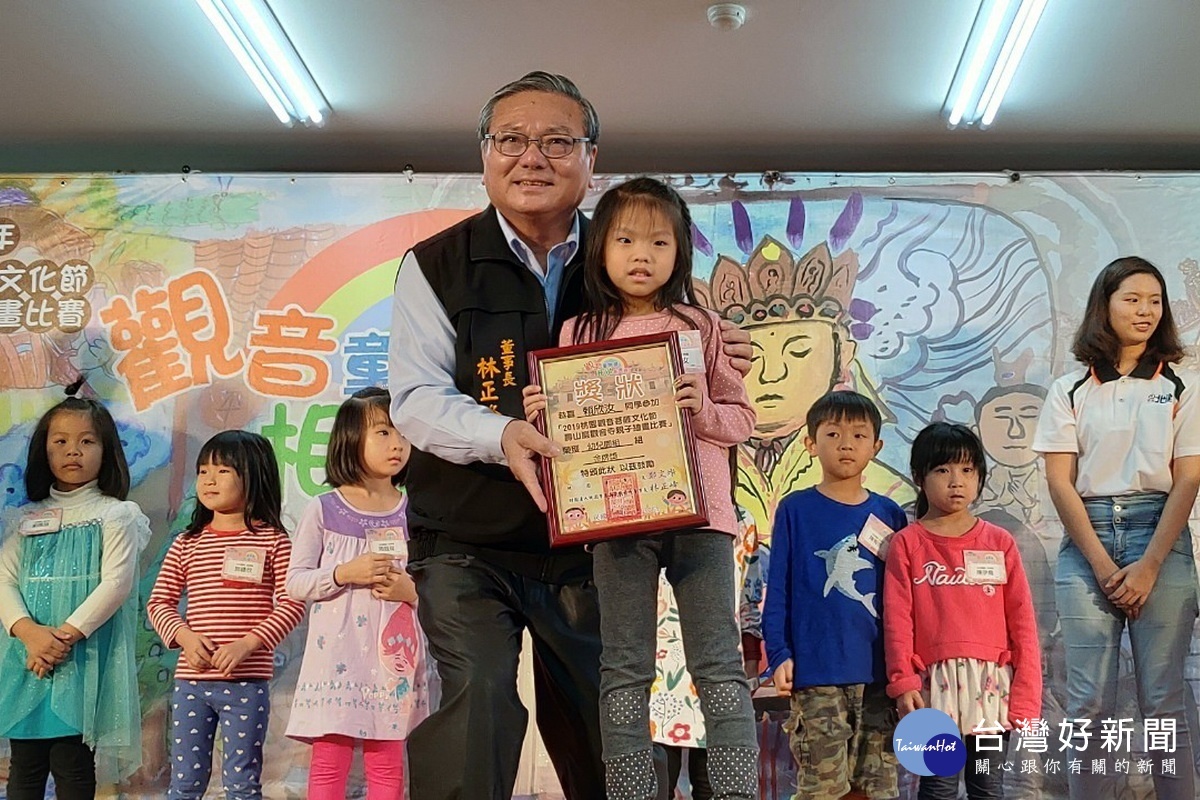 壽山巖觀音寺理事長林正峰頒發親子繪畫比賽得獎者獎狀。