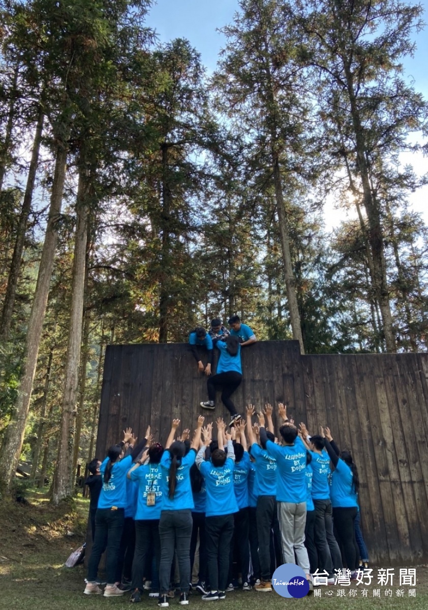 四健會青年團隊合作攀上高牆。