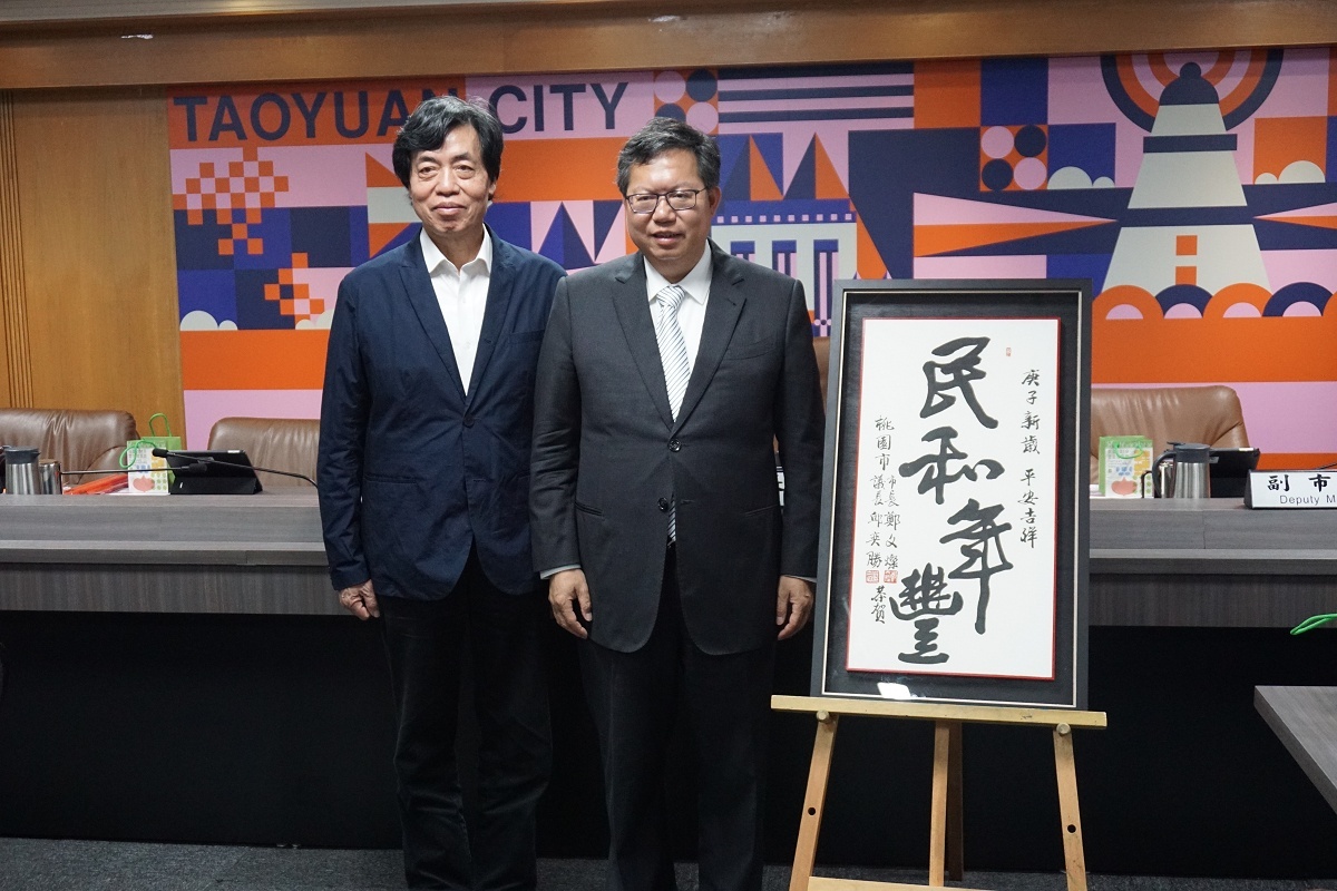 桃園市長鄭文燦與書法名家朱振南在庚子金鼠年春聯「民和年豐」前合影。
