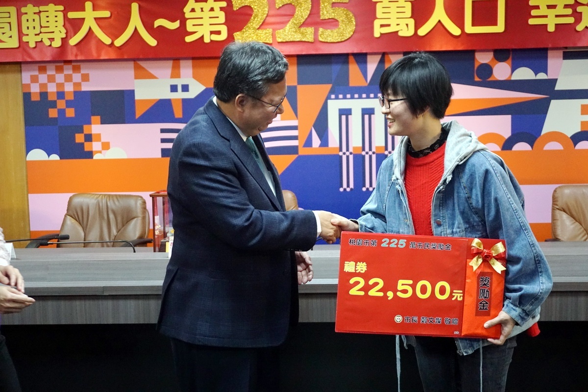 桃園市長鄭文燦與第225萬人口幸運兒呂季芬相見歡,頒贈22500元獎勵金。