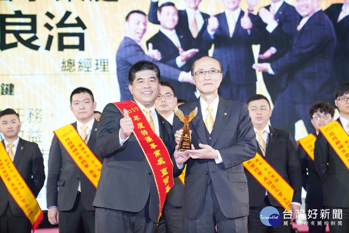 永慶房屋吳良治總經理帶領同仁創造高績效,從孫慶餘董事長手中接過獎盃。