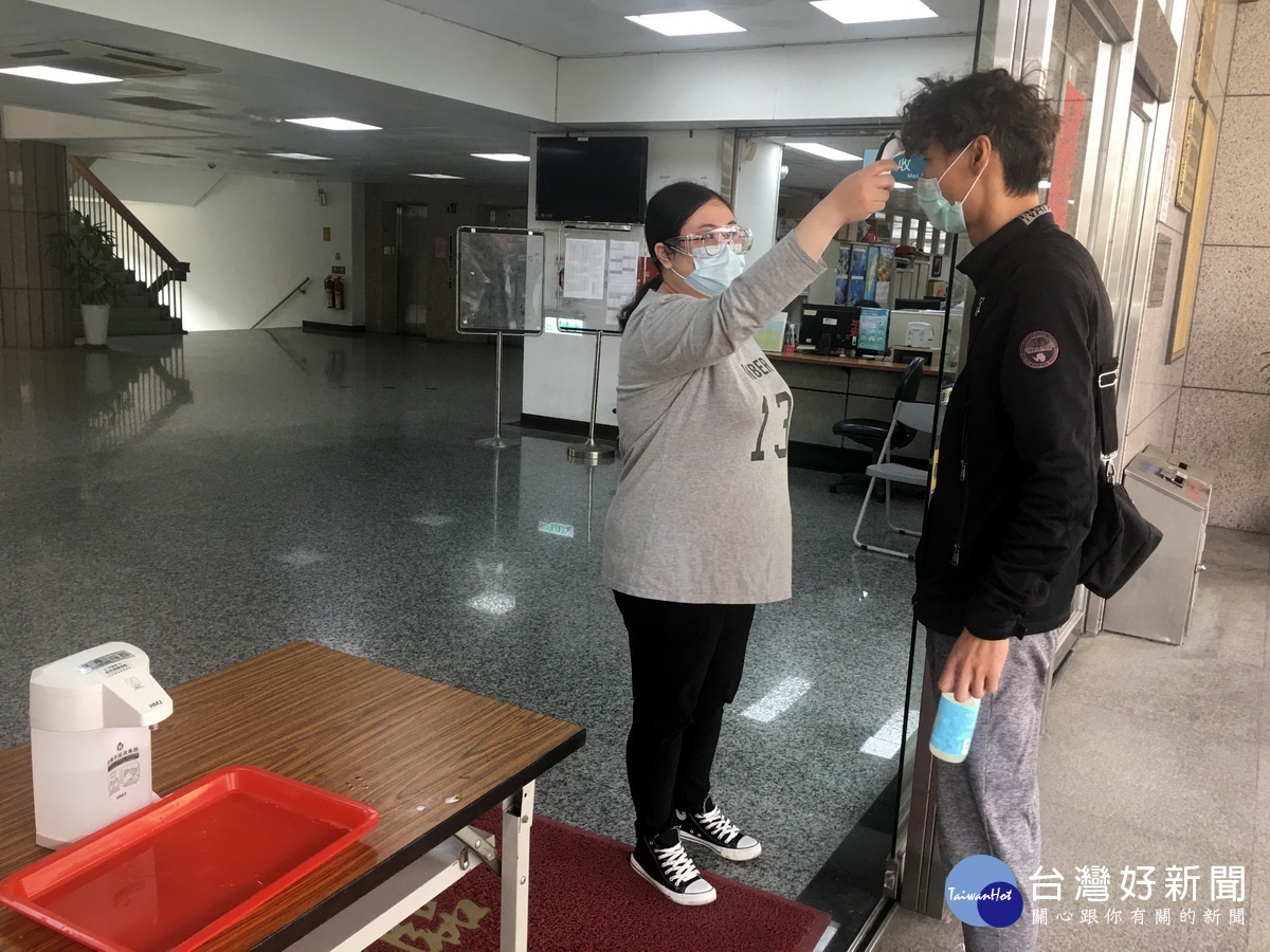 民眾洽公需先量額溫。(記者扶小萍攝)