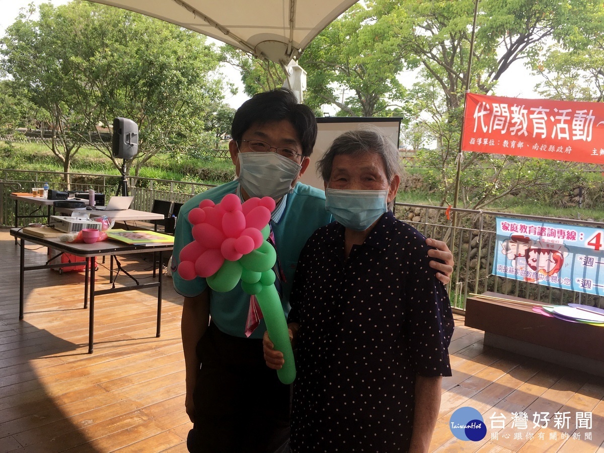 呂建蒼贈康乃馨汽球予9旬的阿嬤。(記者扶小萍攝)