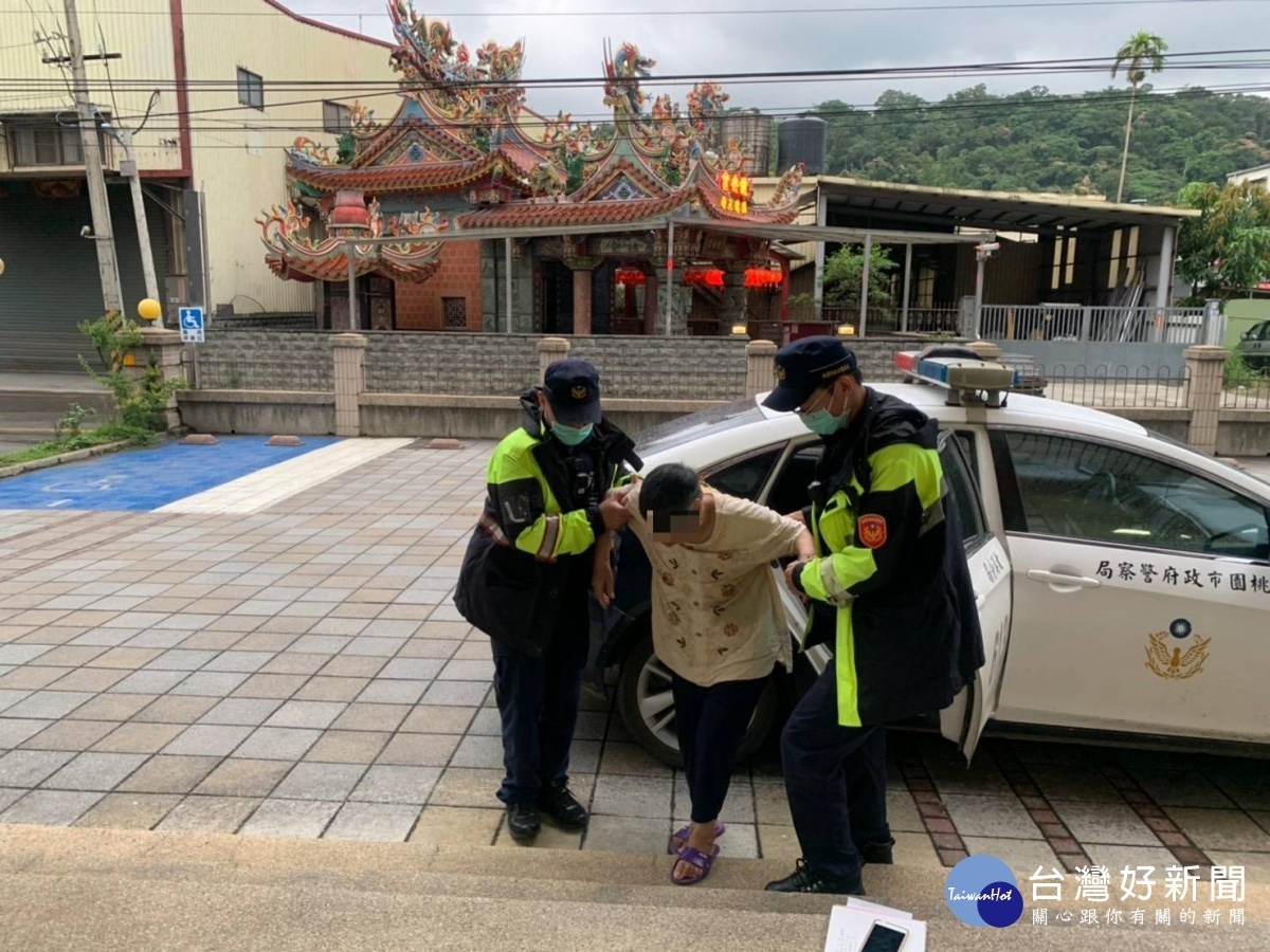謝姓老婦無助的坐在路旁人行道上,員警發現有防走失手環,將老婦人護送返家。