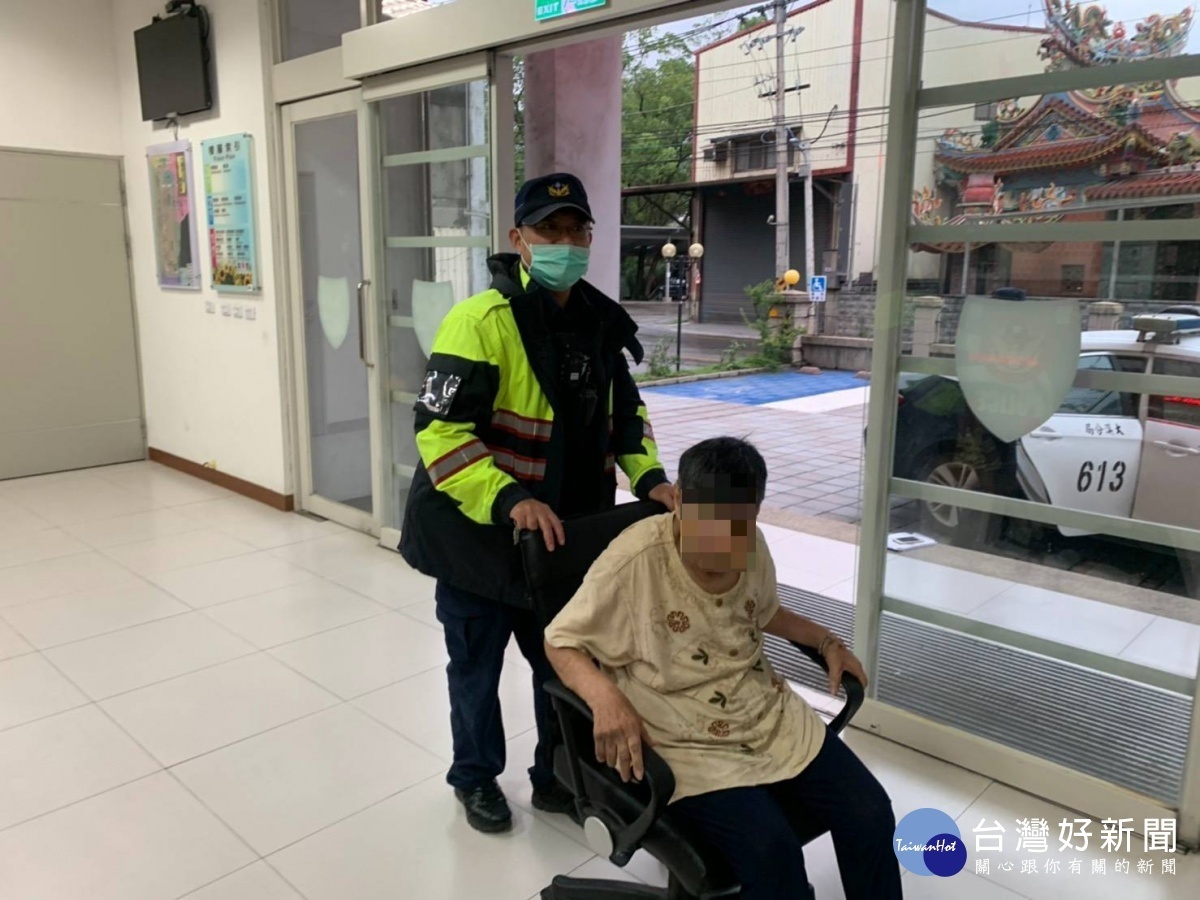 謝姓老婦無助的坐在路旁人行道上,員警發現有防走失手環,將老婦人護送返家。