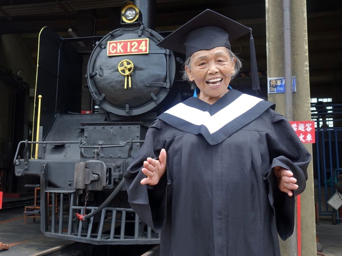 80歲獨居的梁淑妃阿嬤笑著說:「我是班長,每次上下課都要喊起立、立正、敬禮,金促咪!」從不害怕上課拿筆而且從來不缺席。圖/弘道老人福利基金會提供