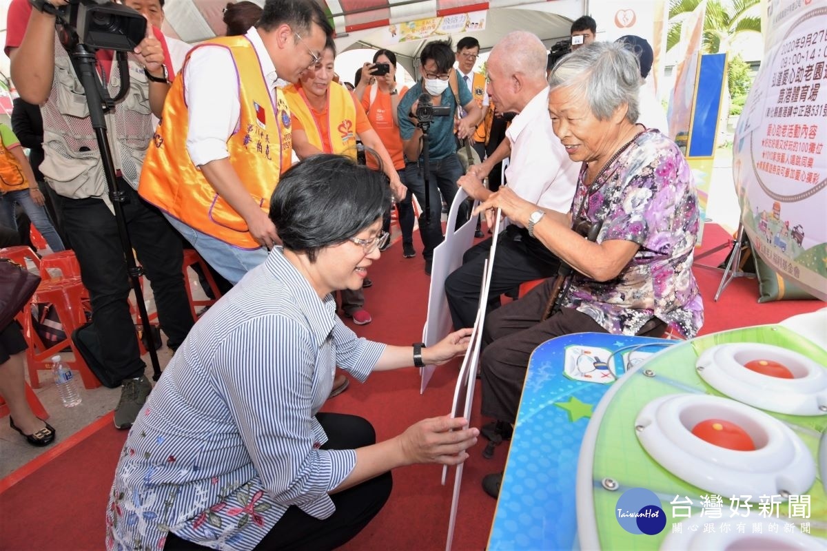 弘道助老愛心園遊會宣傳會上，縣長王惠美黏貼手拿板。