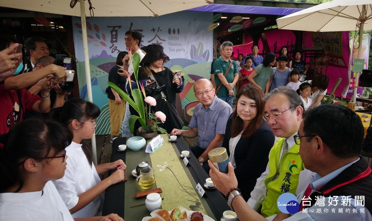 曾明瑞(右1)總幹事為胡忠一署長〈右2〉說明茶席所使用的茶種。(記者吳素珍攝)