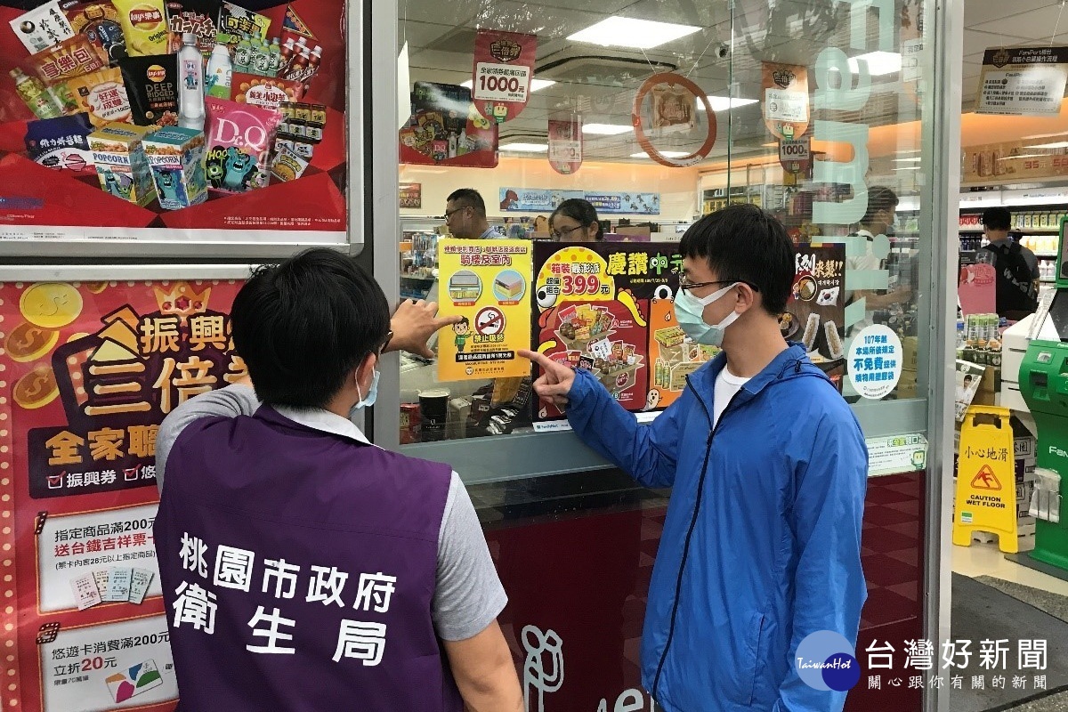 桃園市政府公告1,800處禁菸場所,衛生局人員張貼禁菸海報進行宣導。
