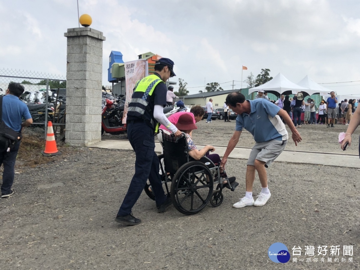 安全維護的員警充當起導護員,幫忙行動不便的老人家走過崎嶇不平的路面,讓名眾感到溫馨。