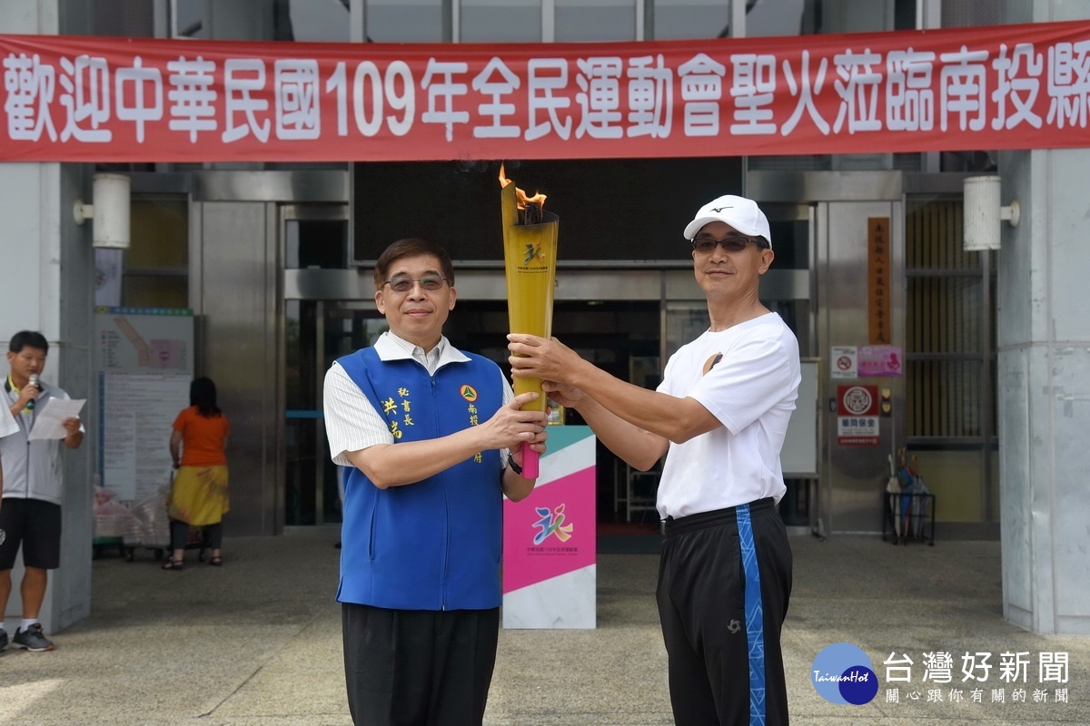 花蓮縣聖火領隊許傳德(右)傳主火予洪秘書長。(縣府提供)