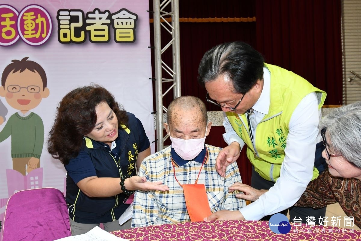 林世賢市長在重陽敬老系列活動記者會上為百歲人瑞蔡金水戴上金鎖片後並致贈紅包。