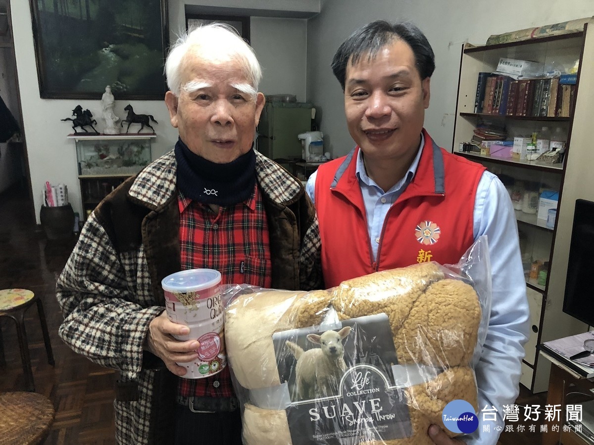新北市榮服處陳組長(右)致贈新店區吳伯伯寒冬送暖物資,吳伯伯馬上將圍脖套上。