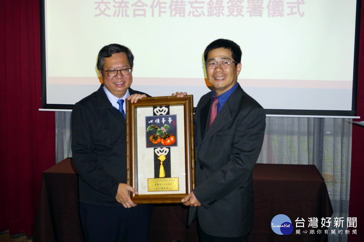 桃園市長鄭文燦致贈紀念品予台中市產業故事館發展協會理事長吳德利。