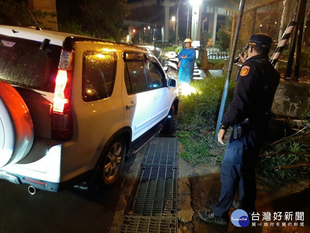 王姓婦人路況不熟,右前輪直接陷入水溝,警民合力抬車疏解,交通恢復順暢