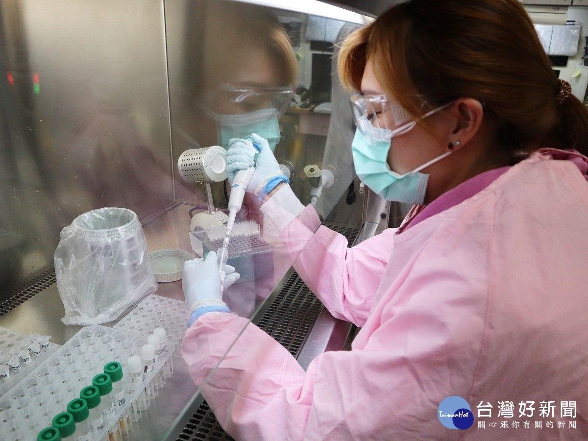 醫檢師在具負壓設備的安全操作櫃中,裝備完整的防護裝備下進行檢驗