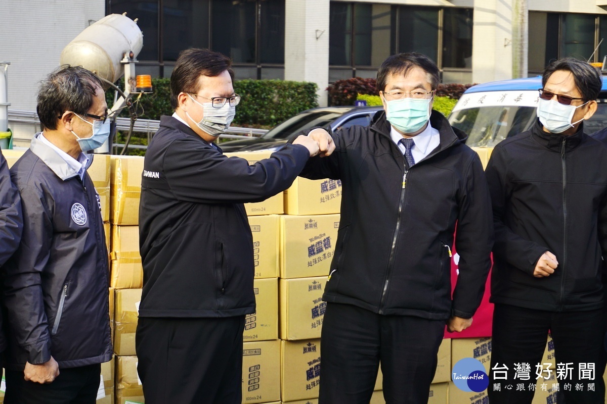 捐贈議式中，桃園市長鄭文燦與台南市長黃偉哲「擊拳」相互問好。