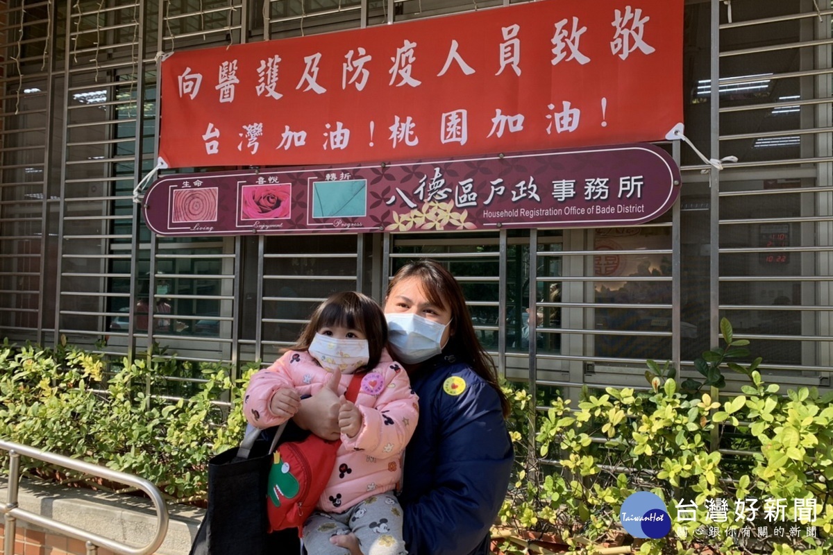 民眾在掛有向醫護及防疫人員加油打氣的紅布條前留影,表達支持醫護的行動。