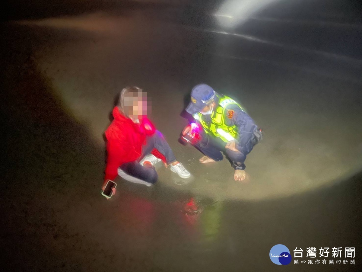 邱姓女子半身在水中並不斷呼救，員警見狀趕緊衝上前將人拉回岸邊，及時挽救一條寶貴的生命