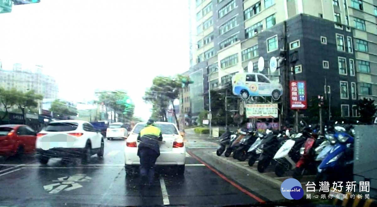 雨中車輛拋錨在路中，幸有警熱心協助推車解圍