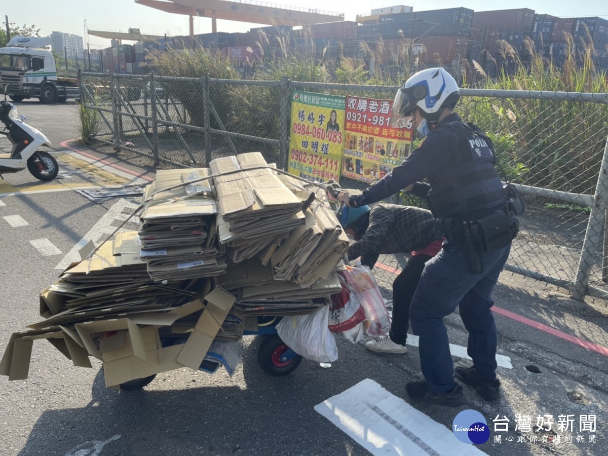 警方發現一拾紙箱的推車婦人，周圍紙箱散落一地，立即下車協助整理紙箱