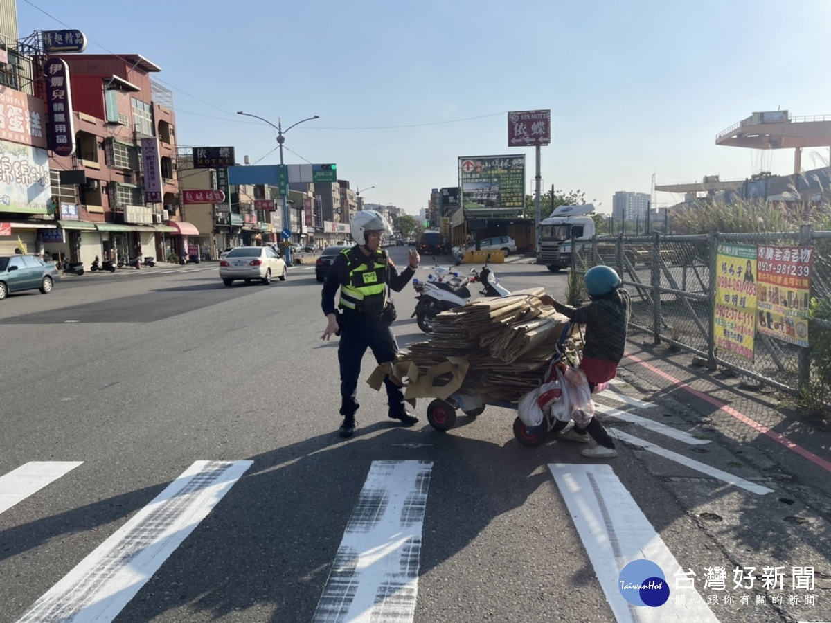 警方發現一拾紙箱的推車婦人，周圍紙箱散落一地，立即下車協助整理紙箱